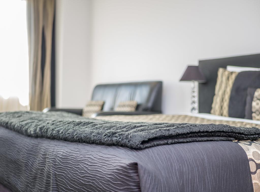 Bellano Motel Suites Крайстчёрч Экстерьер фото A bed with a throw
